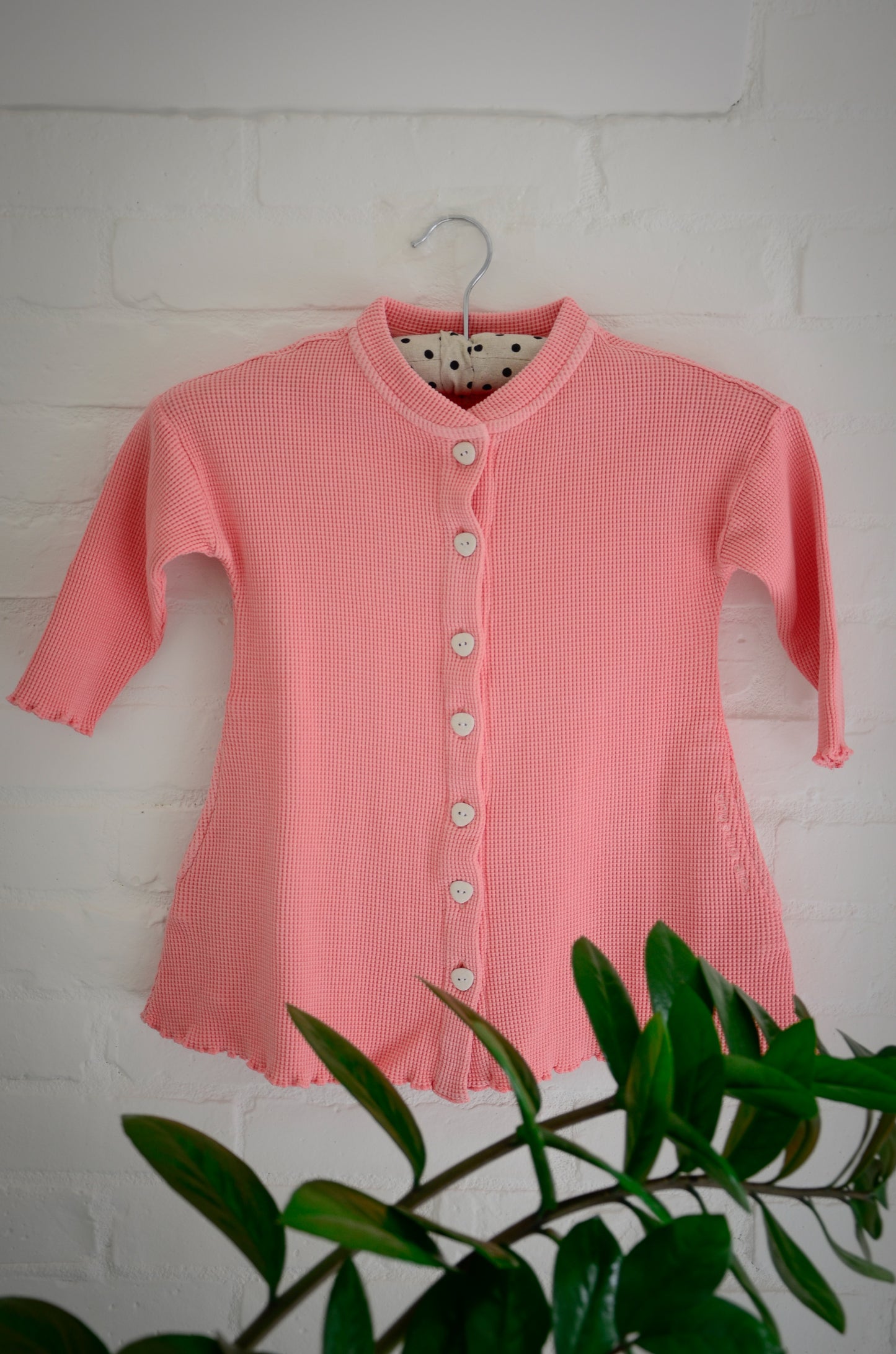 An image of a long sleeve dress with pockets and eco friendly buttons. The dress is made with 100% organic cotton waffle and garment dyed in natural minerals. It's breathable and perfect for all year round wear.