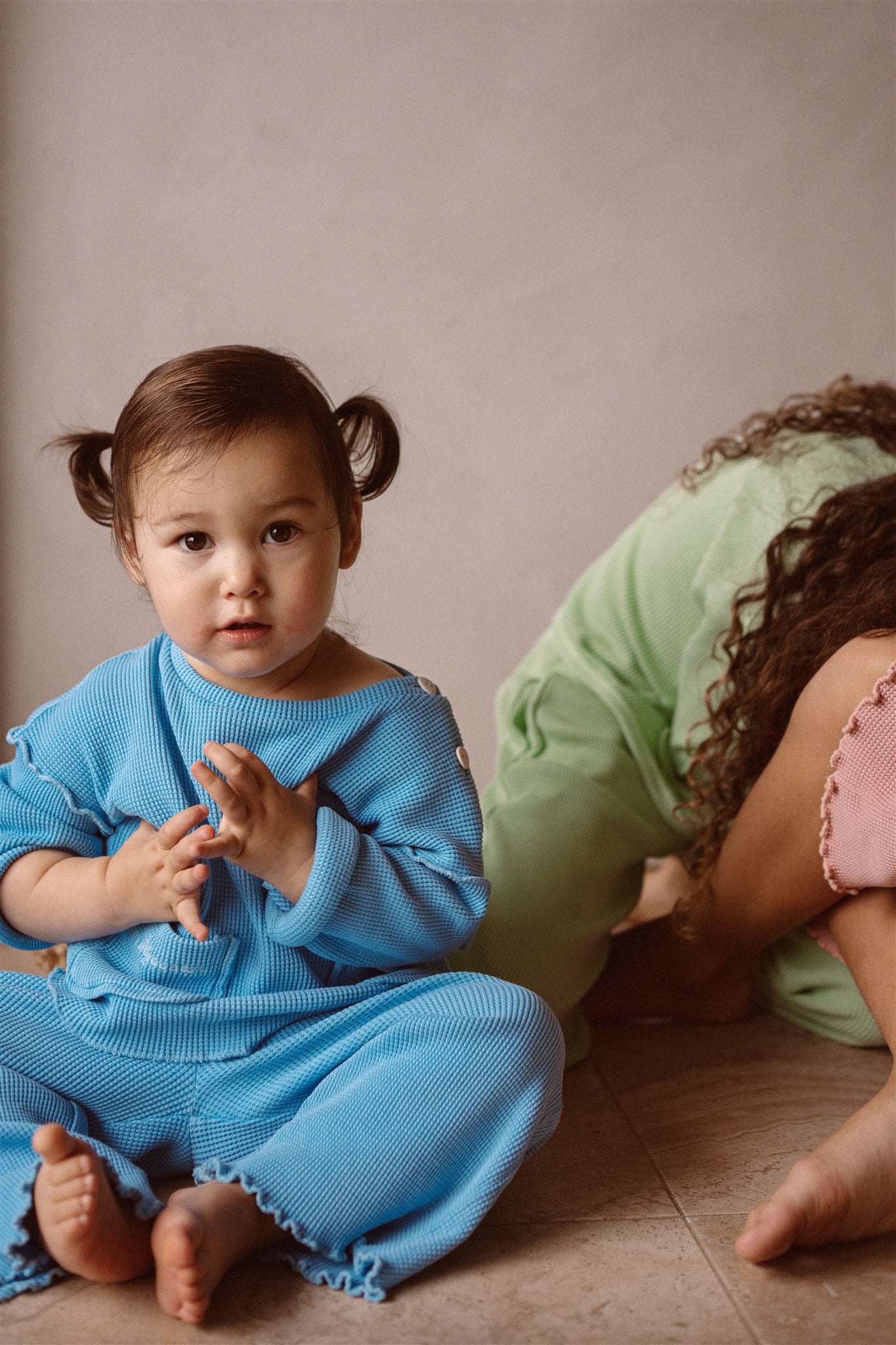 A little girl wearing organic cotton kids top and pants in sky blue colour. The set is made with non-toxic natural minerals.