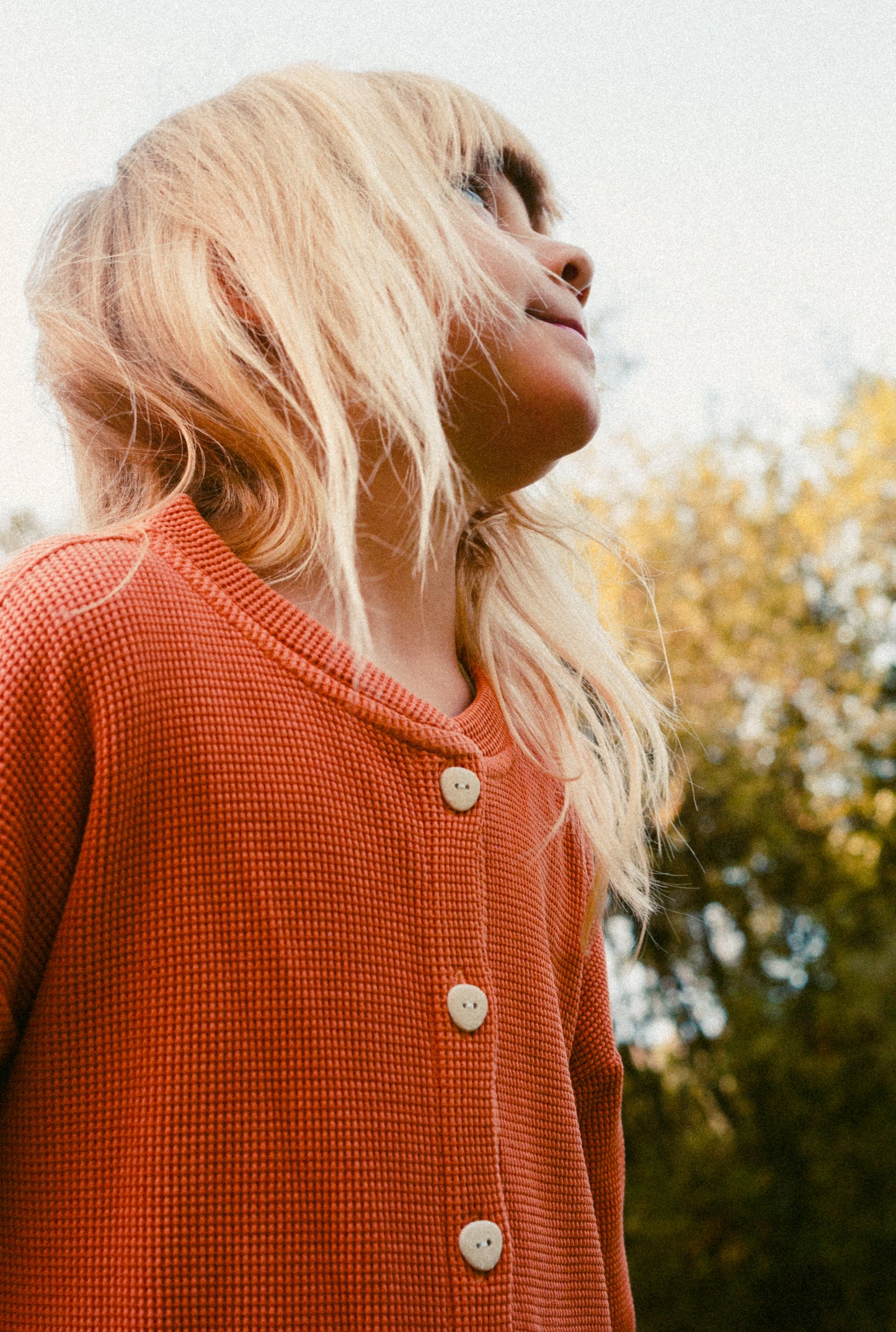 A 6 year old girl is wearing a beautiful sienna dress made with 100% organic cotton waffle and garment dyed in natural minerals. It is breathable and comfortable to wear all year round.