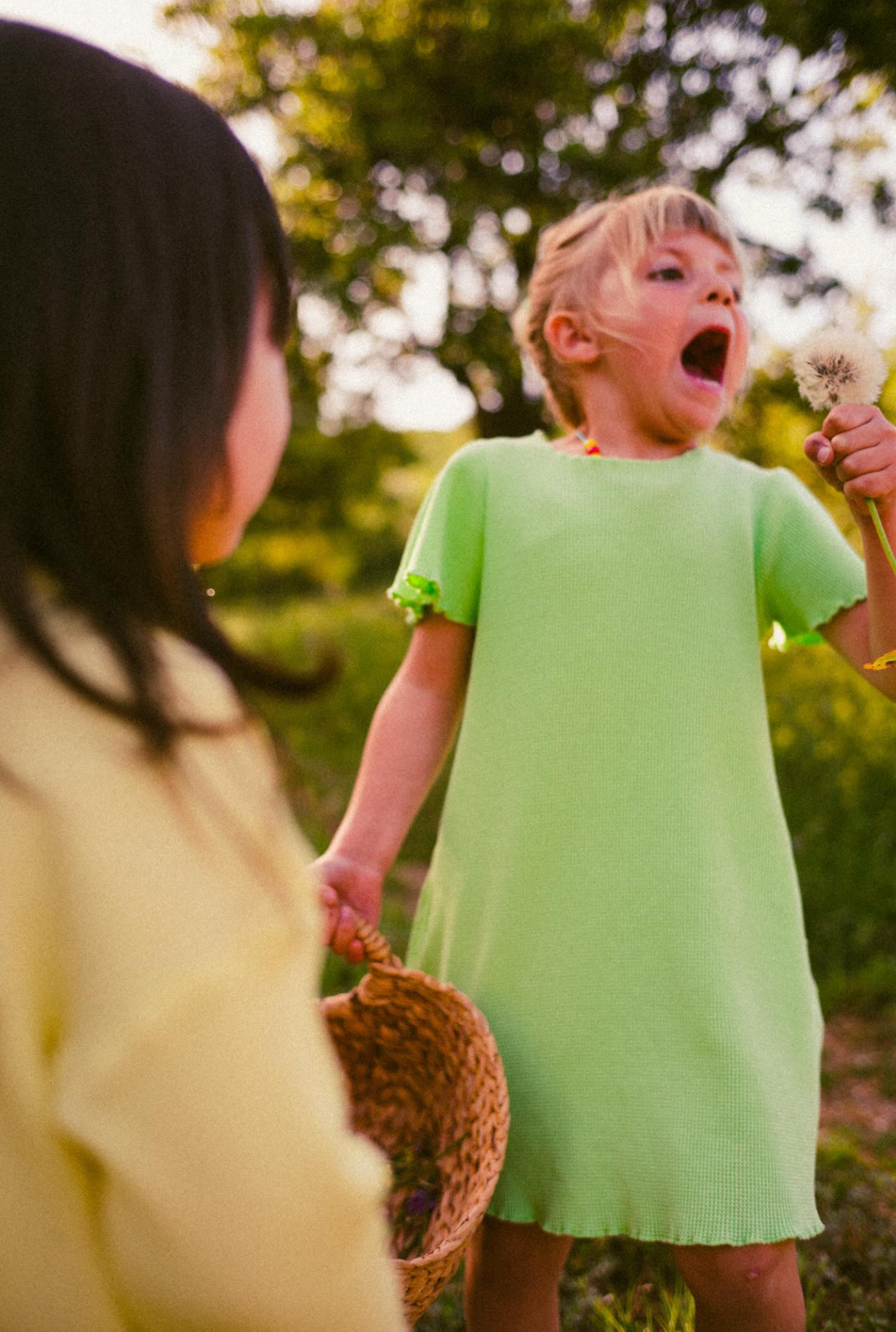 Two little girls exploring nature. Dressed in comfortable and colourful dresses made from organic cotton and natural minerals.