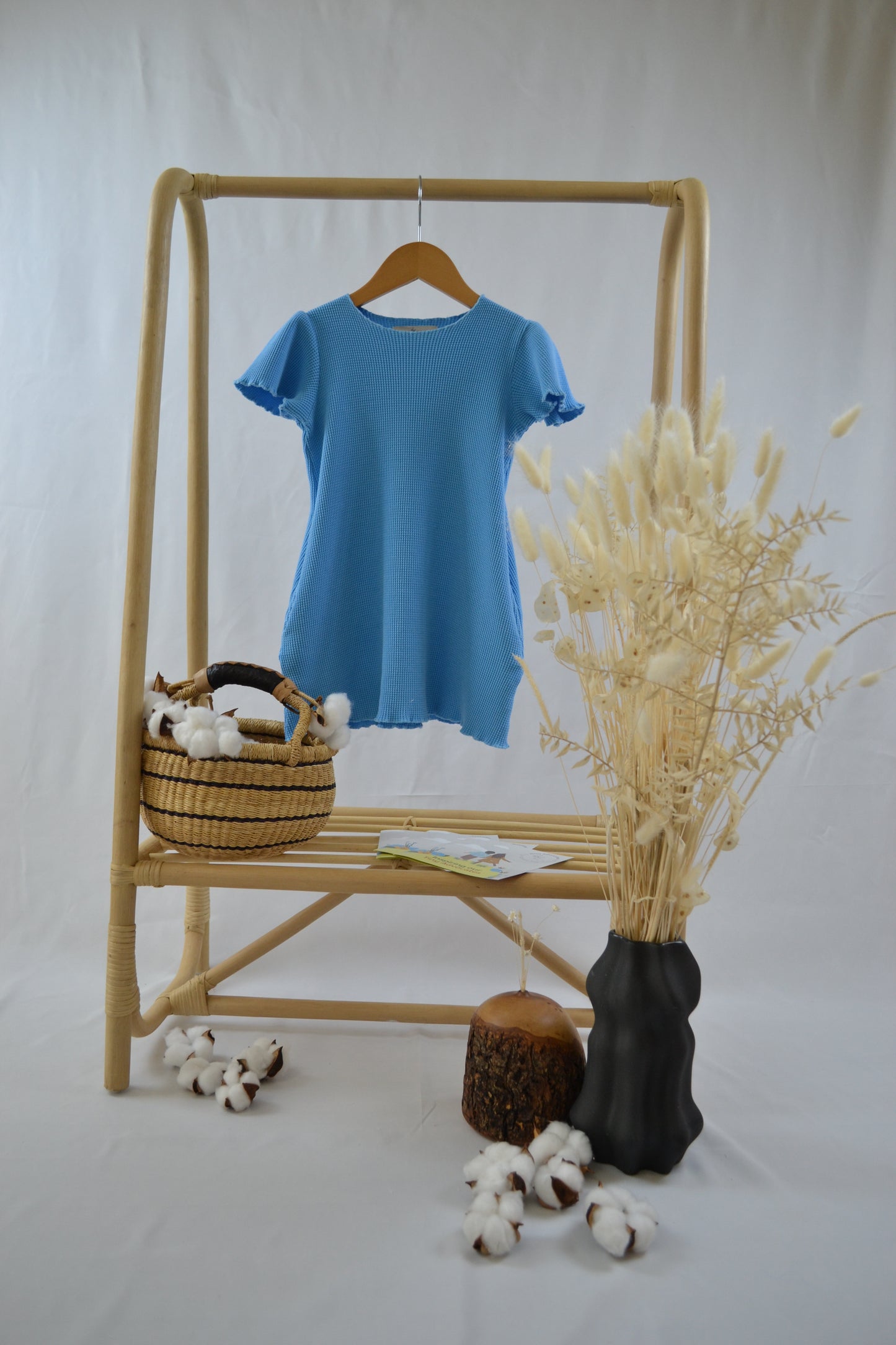 A photo of a beautiful blue dress for kids. Made from buttery soft 1005 organic cotton and garment dyed with natural minerals.