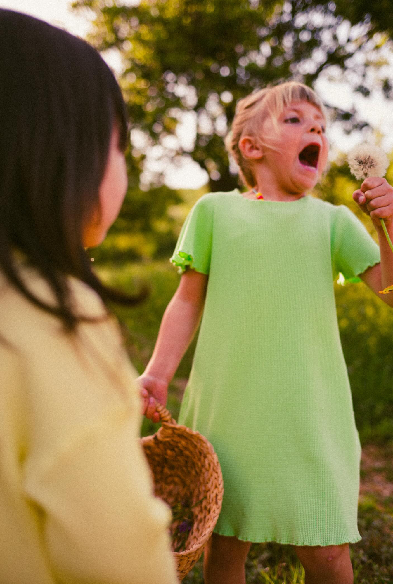 Two little girls exploring nature. Dressed in comfortable and colourful dresses made from organic cotton and natural minerals. 