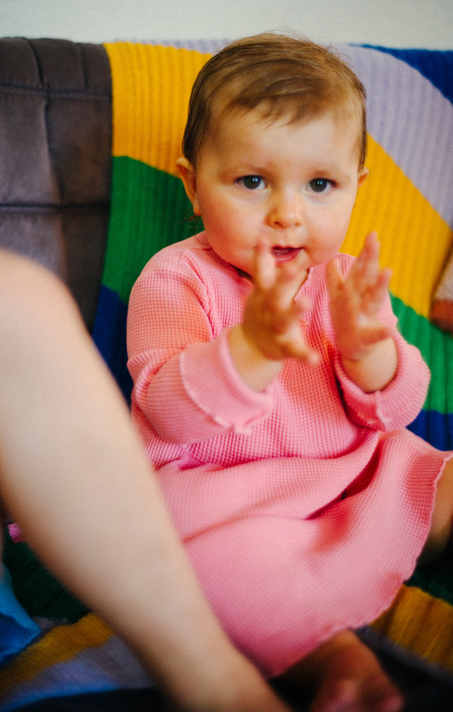 A little girl playing at home. She is wearing a comfortable, buttery soft organic cotton dress with pockets.